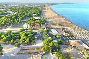 An aerial view of a coastal resort with a beach, green areas, and various buildings. - San Pietro Holiday Retreat, Lalzit Bay, Albania (Lalzit Bay)