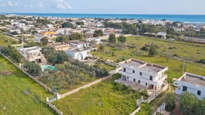A residential area with houses, a swimming pool, and a view of the sea. - Le Bianche Apt1 with Garden Near The Sea, Manduria, Italy (Manduria)