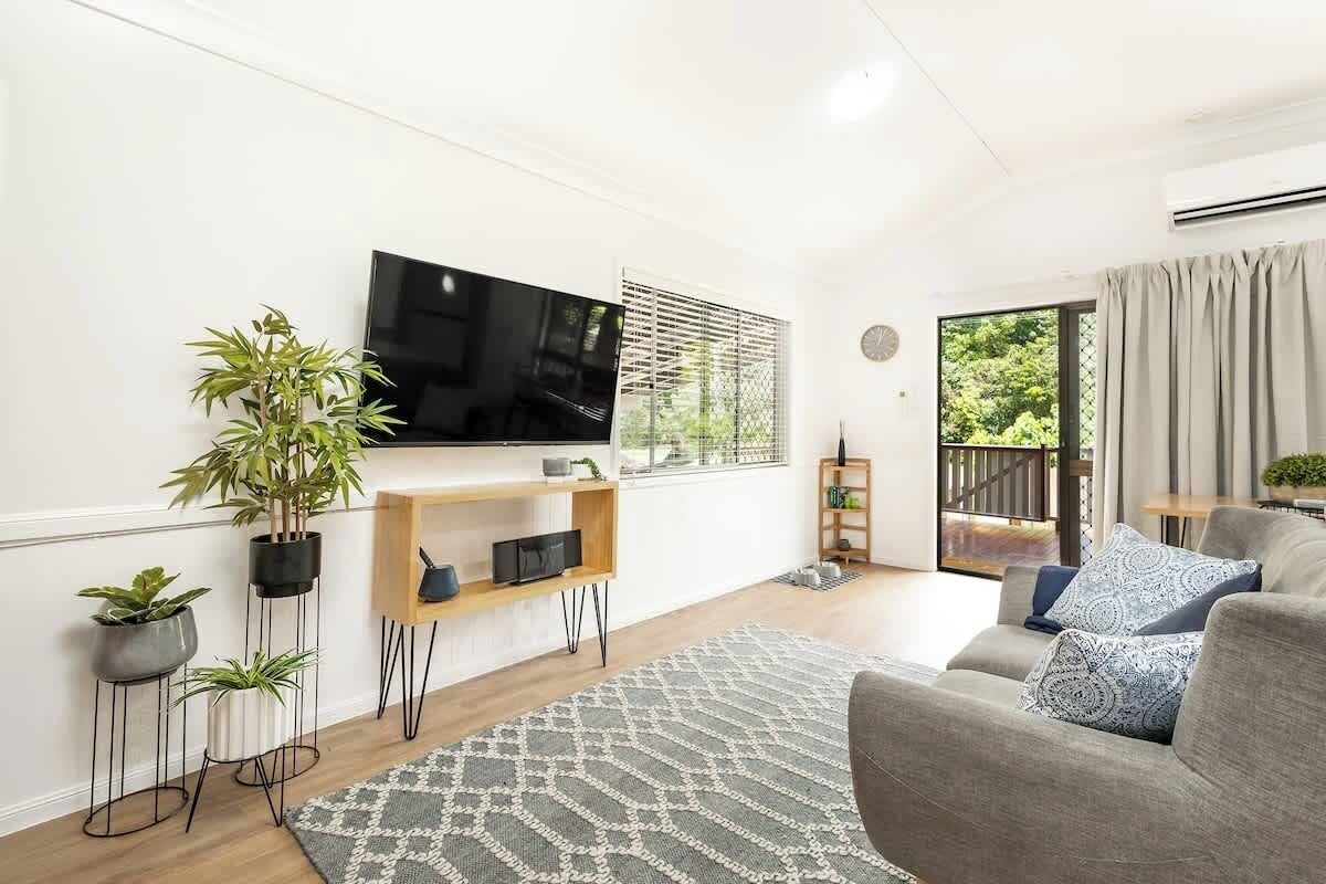 Relax into the cosy living area after a day by the coast, with soft natural light, comfortable seating, and cooling air conditioning creating an easy space to unwind.