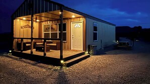 A small, single-story building with a porch, a door, and a window. - Desert Quail Oasis: Style, Comfort & Easy Access (Terlingua)