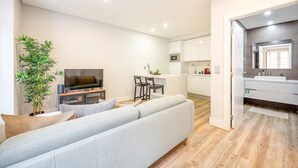 Eine moderne Wohnung mit Wohnzimmer, Essbereich, Küche und Badezimmer.