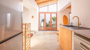 Una cocina moderna con techo de madera, un ventanal y vistas al exterior.