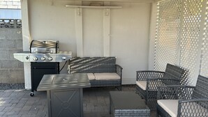 An outdoor patio with a grill, wicker furniture, and a covered ceiling. - Close to hiking trails, Central home, 3 bedrooms! (Phoenix)