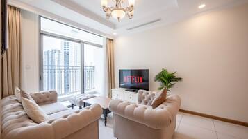 A modern living room with a large window, a television, and two sofas.