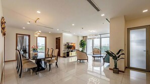 A modern dining area with a glass table, chairs, and a view of the city. - Vinhomes Central Park - KIMI Residences (Ho Chi Minh City)
