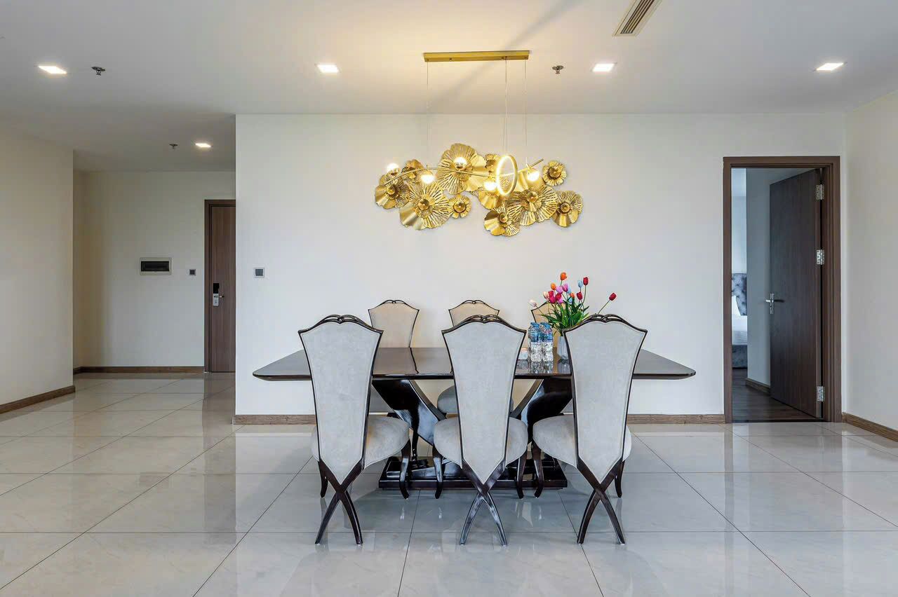 Un comedor con una mesa rectangular, cuatro sillas y un adorno en la pared.