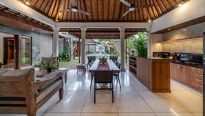 A spacious open-plan living area with a dining table, sofas, and a kitchen area. - Villa MD 2 Stylish 3 BR w/ Sunny Pool at Prime Eat Street (Badung)