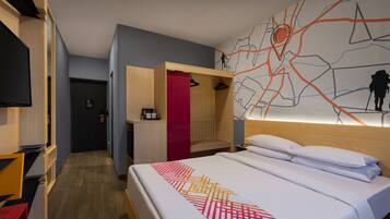 Habitación de hotel con cama, televisor, armario y pared con diseño de mapa.