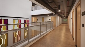 A modern hotel corridor with a wooden floor, a glass railing, and a mezzanine level. - Ginger Nagpur Airport Road (Nagpur)