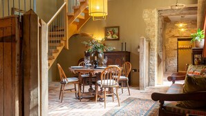 A dining area with a wooden table, chairs, and a chandelier.