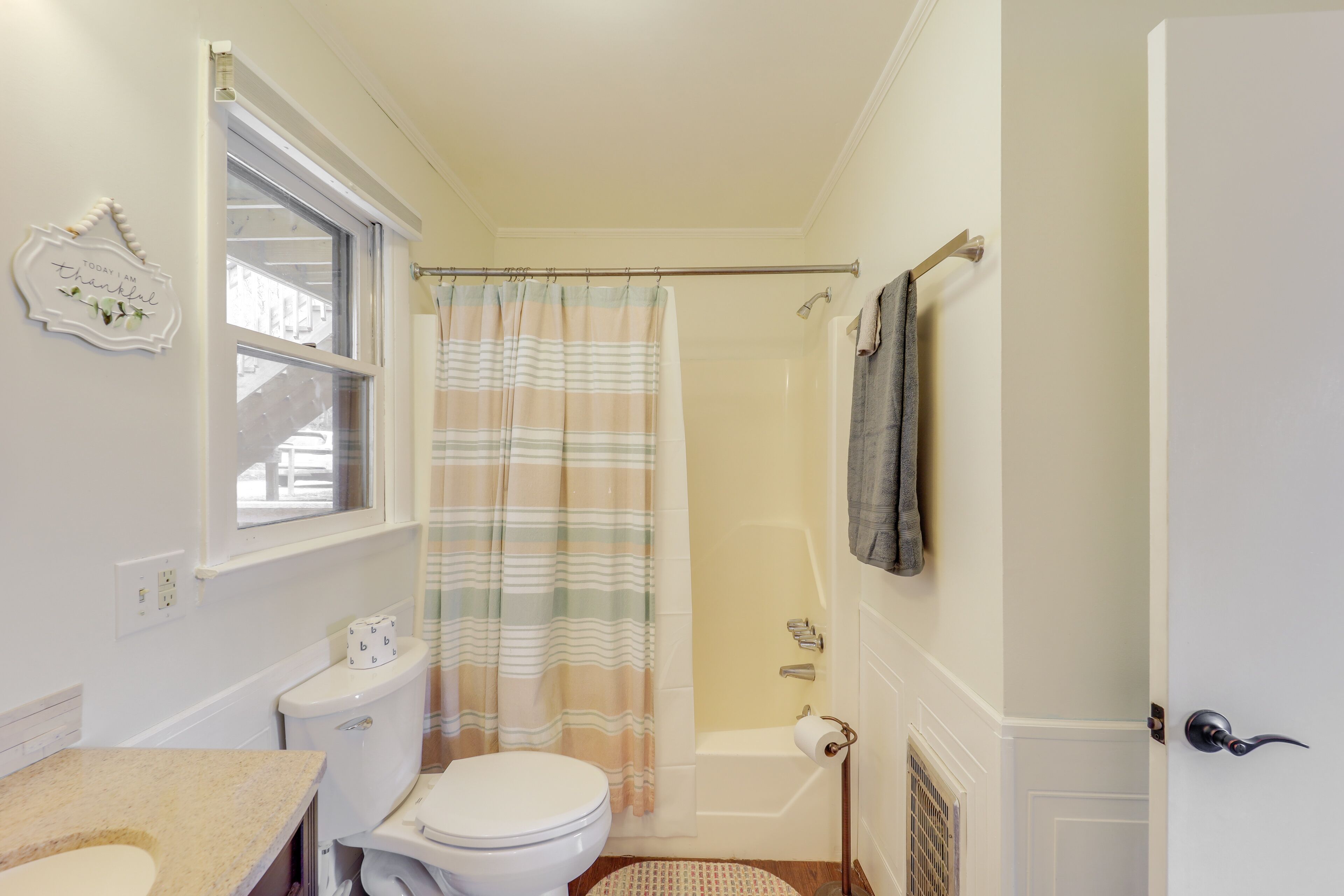 Een badkamer met toilet, wastafel, douche en een handdoekrek.
