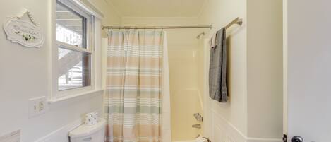 Een badkamer met toilet, wastafel, douche en een handdoekrek.