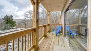 A wooden deck with a glass door, two blue chairs, and a view of a mountainous landscape. - Beech Mtn Studio < 1 Mi to Skiing: Bring Your Pet! (Beech Mountain)