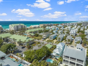 A coastal resort with multiple buildings, a swimming pool, and a view of the ocean.