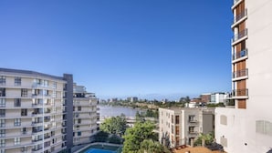 Un immeuble résidentiel doté de nombreux balcons, d’un court de tennis et d’un espace piscine.