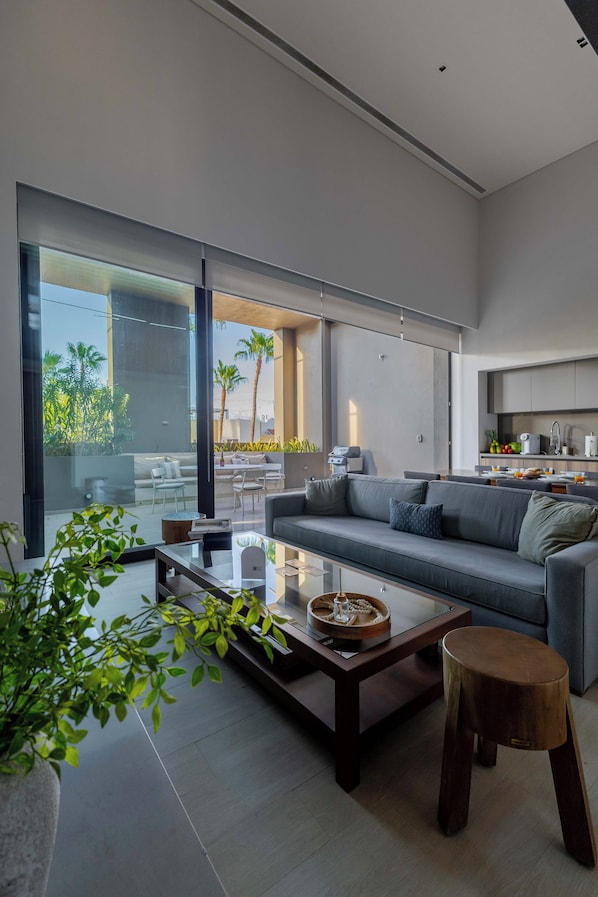 Una sala de estar moderna con un sofá, una mesa de centro y vistas al exterior.