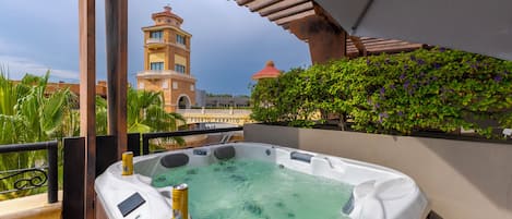 A hot tub with a view of a building with a clock tower.