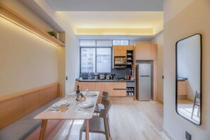 Cozy living space with dining area and kitchenette, featuring a table for four and modern amenities.