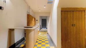 A hotel corridor with a checkered floor, a wooden door, and a counter. - Capitalia | Chill Stay & Near Condesa & Museums (Ciudad de México)