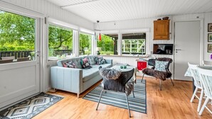 A cozy room with a light blue sofa, a dining table with chairs, and a TV mounted on the wall. - "Fridtjof" - 550m to the fjord by Interhome (Hemmet)