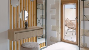 A modern bathroom with a wooden ceiling, a vanity with a round mirror, and a round stool. - Fillio luxury villa (Αδελιανός Κάμπος)