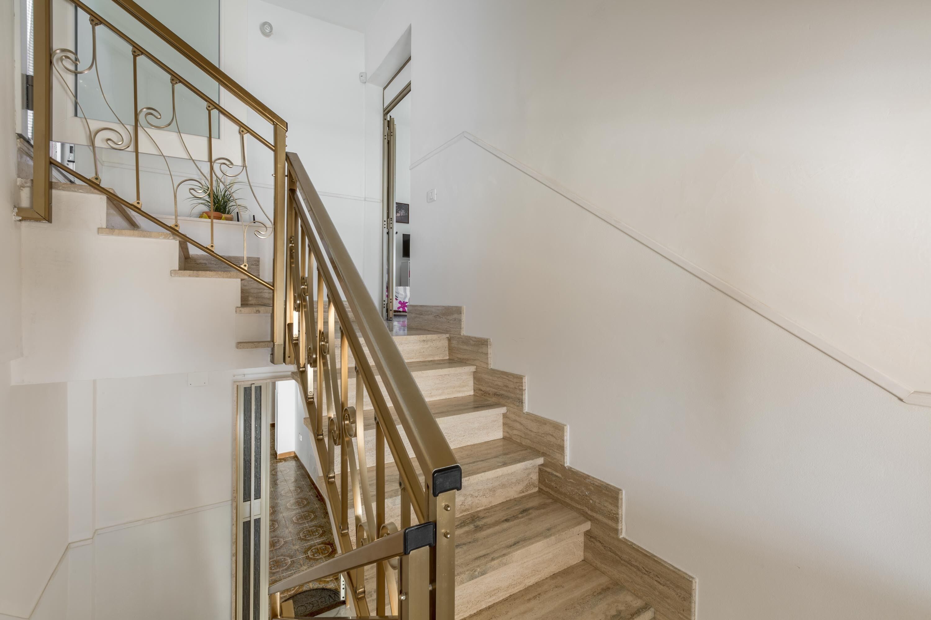 A staircase with a wooden finish and a metal railing.