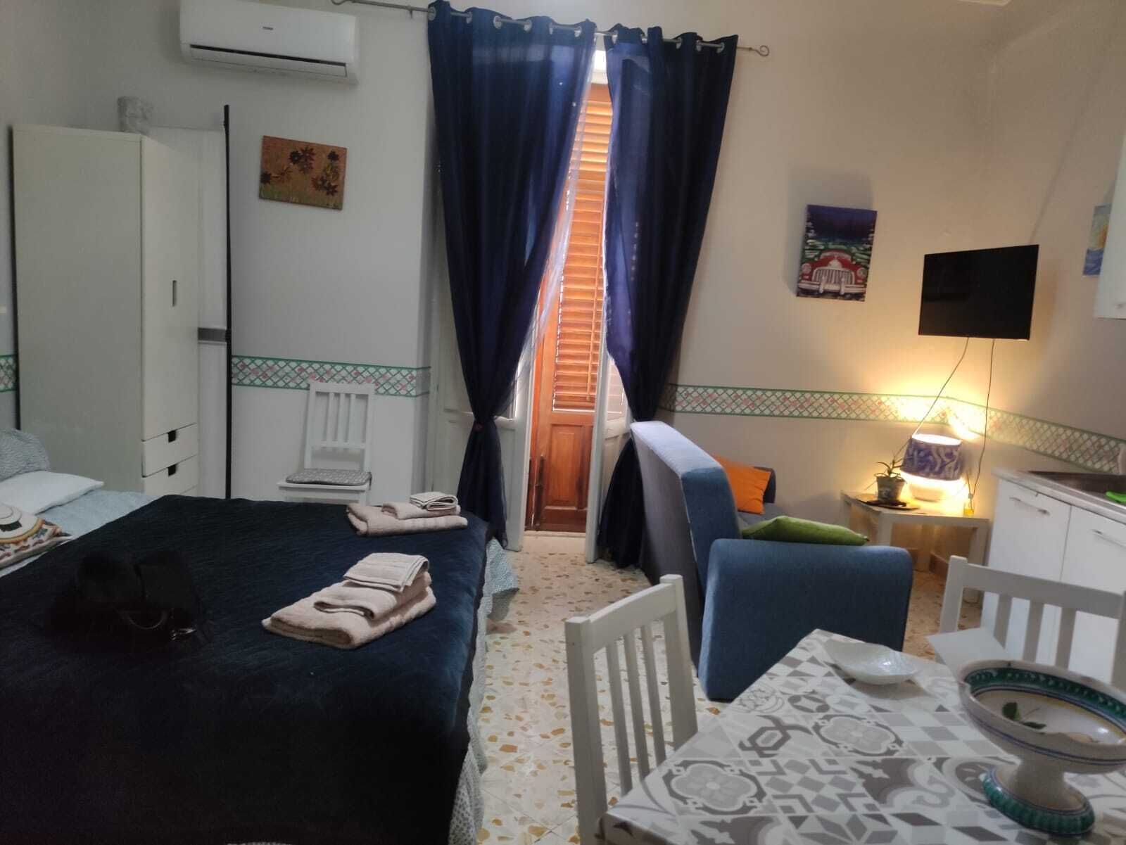 Ein Hotelzimmer mit Bett, Stuhl, Tisch mit Lampe und Fernseher.