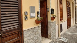 Eine schmale Gasse mit Kopfsteinpflaster, Holztüren und nummerierten Briefkästen.