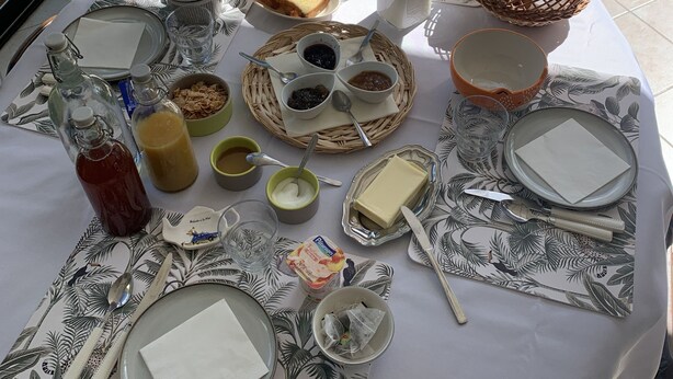 A table set for breakfast with bread, butter, jam, and tea. - A guest room for rent (possibility of renting 2 rooms) (Vienne en val)