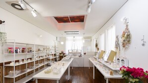 A clean, well-organized retail space with white shelving, tables, and a central display area. - SEMINAR PLAZA ROYAL FUJI (Fujikawaguchiko)