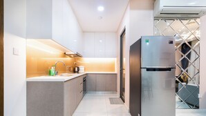 A modern kitchen with a stainless steel refrigerator, a built-in oven, and a microwave. - Fusion RiverGate Apart Infinity Pool (Ho Chi Minh City)