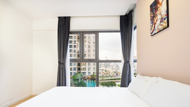 A hotel room with a large window, a bed, and a painting on the wall. - Fusion RiverGate Apart Infinity Pool (Ho Chi Minh City)