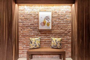 Relax in a charming seating area with a bench and patterned cushions, complemented by a framed artwork on the wall.