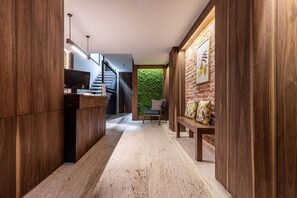 Stylish hallway with a bench and artwork, leading to a seating area and staircase.