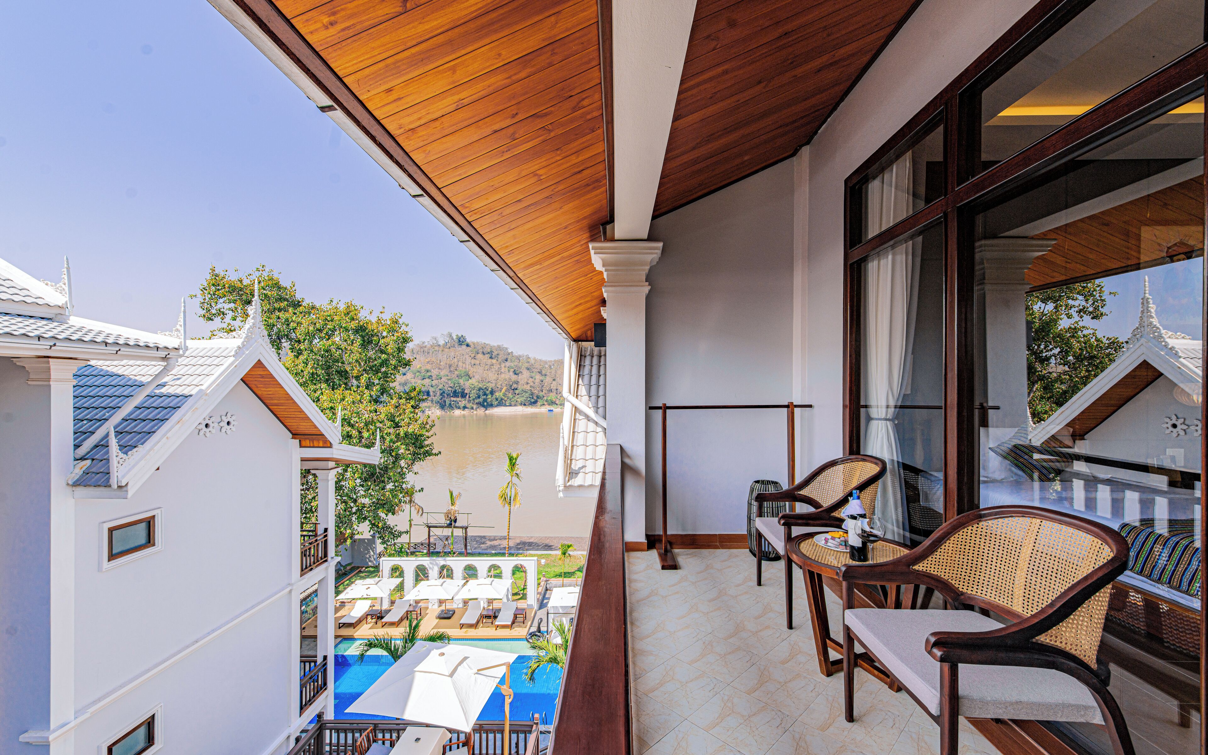 A balcony with a view of a swimming pool and a mountain.