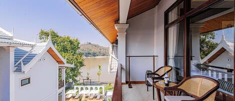 A balcony with a view of a swimming pool and a mountain.