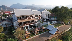 A multi-story hotel with a traditional architectural style, featuring balconies and a rooftop area. - Relaxful Hotel (Luang Prabang)