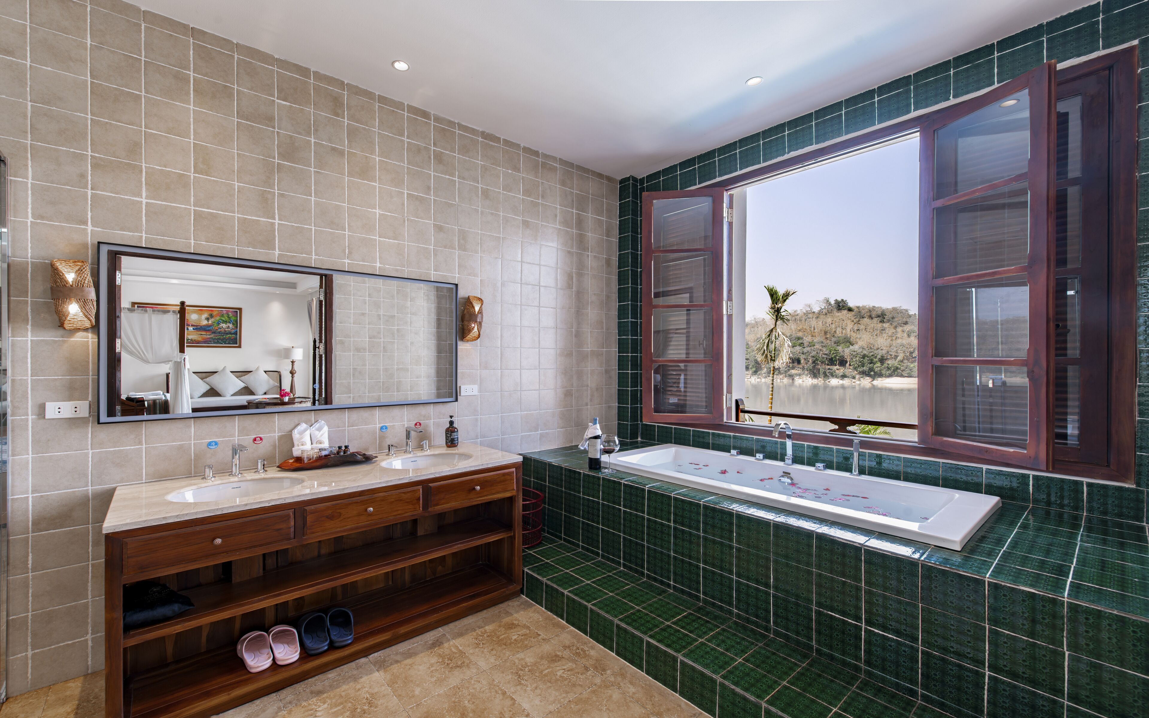A bathroom with two sinks, a large mirror, and a bathtub.