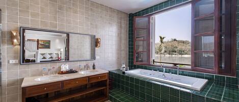 A bathroom with two sinks, a large mirror, and a bathtub.