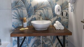 A bathroom with a large mirror, a white sink, and a towel rack.