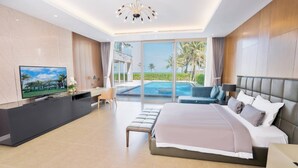 Ein modernes Schlafzimmer mit einem großen Bett, einem Fernseher und Blick auf einen Pool.