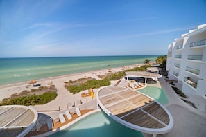 A resort with a pool, beach, and ocean view.