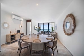A dining area with a round table, chairs, and decorative wall mirrors.