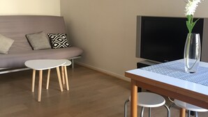 Un salon moderne avec un canapé, une table basse et un téléviseur.