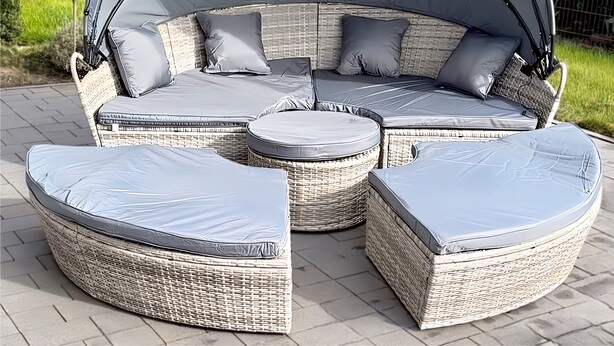 A sectional outdoor seating area with a curved canopy, cushioned seating, and a round table. - Ferienhaus am Glück (Bad Zwischenahn)
