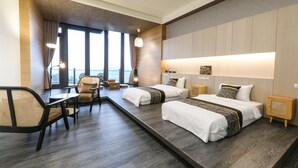 Ein Hotelzimmer mit zwei Betten, einem Schreibtisch und einem Stuhl.