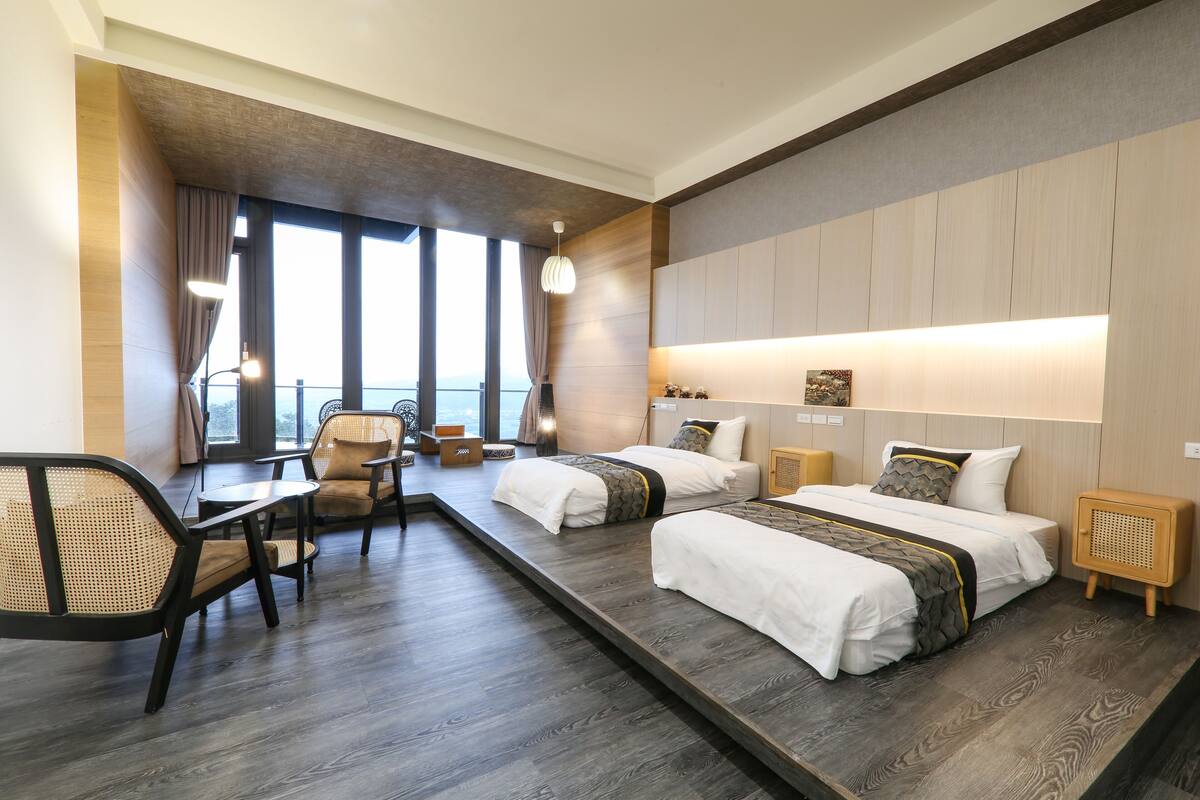Habitación de hotel con dos camas, un escritorio y una silla.