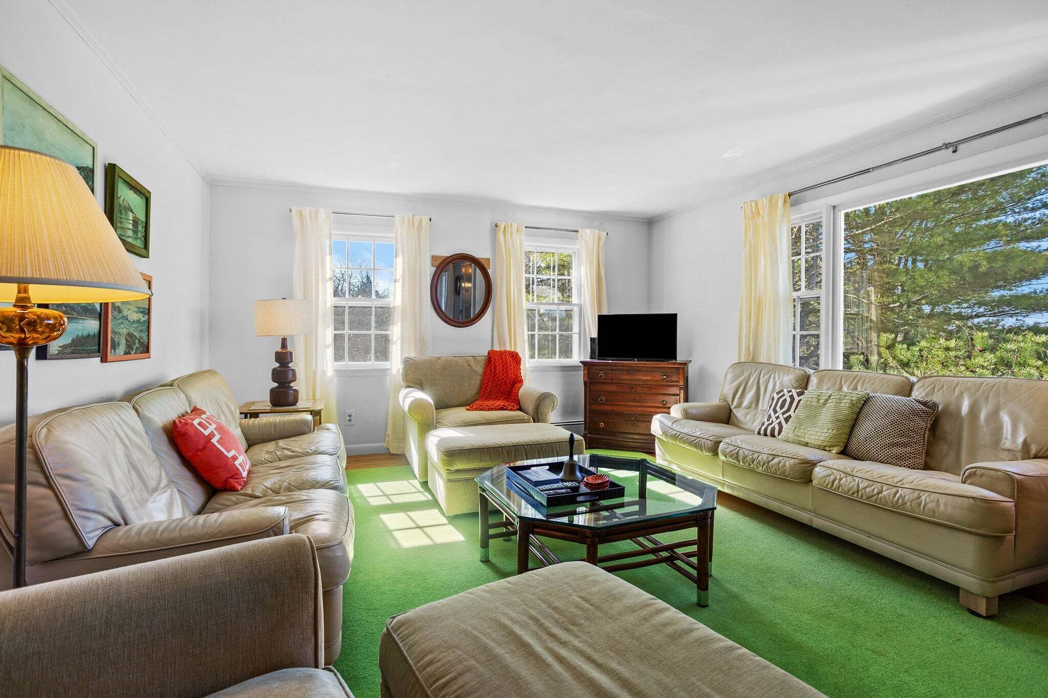A living room with two sofas, a coffee table, a TV, and a window with curtains.