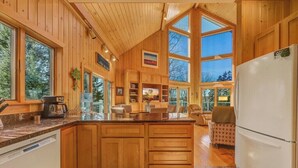 Una cocina amplia con gabinetes de madera, una isla grande y un refrigerador blanco.