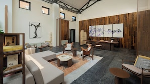A spacious lobby with a high ceiling, modern furniture, and artwork on the walls. - Jiangnan House  Yangcheng Lake (Suzhou)